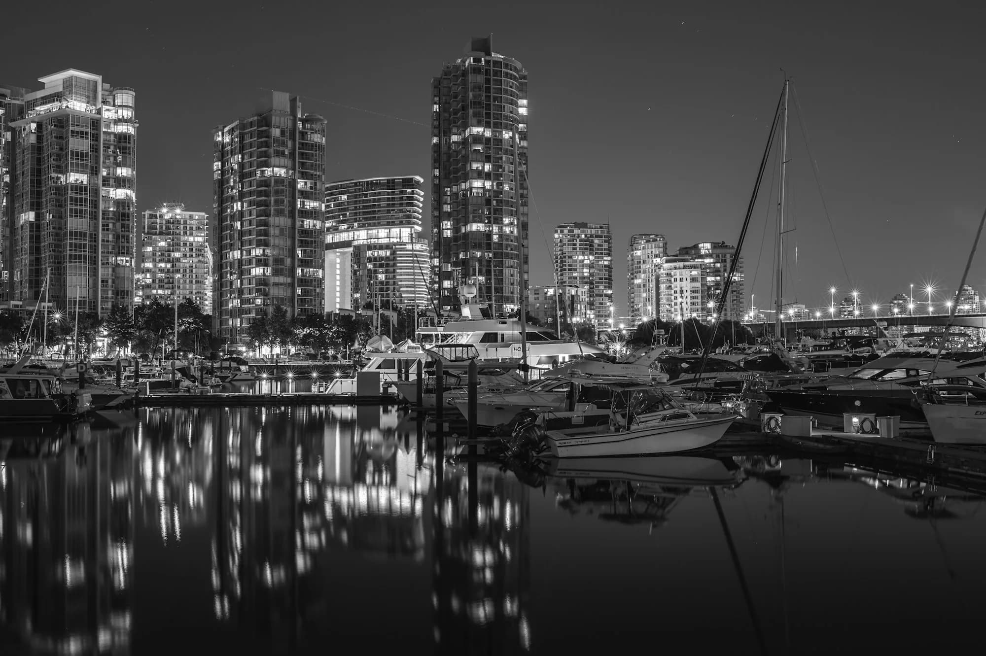 Yaletown Seawall and marina with downtown Vancouver residential towers along False Creek at night